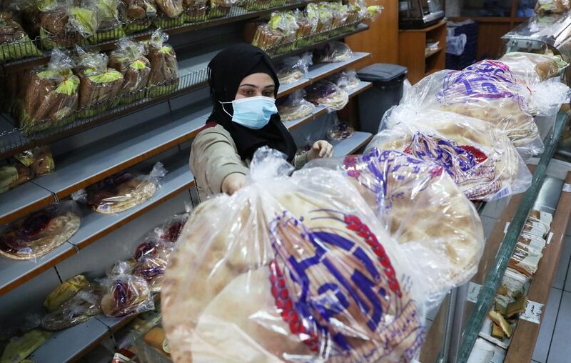 A vendor wearing a face mask arranges bread for sale inside a bakery in Beirut, Lebanon. Reuters