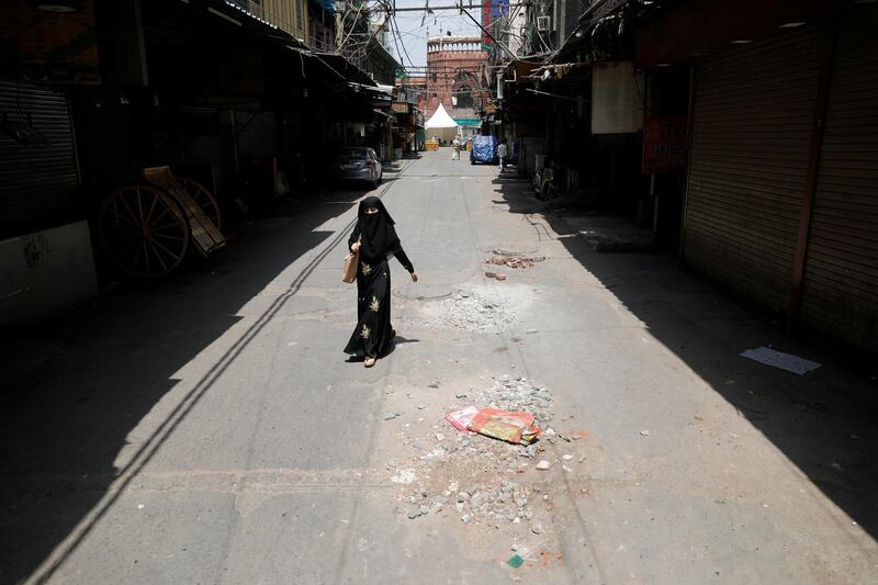 A woman walks on a deserted street  in the old quarters of Delhi, India. Reuters