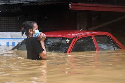 A resident makes her way through a flooded street to shelter after Typhoon Vamco hit, in Marikina City, suburban Manila on November 12, 2020.  / AFP / Ted ALJIBE
