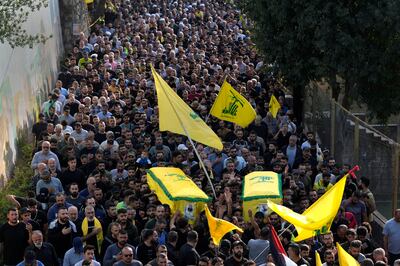 Hezbollah supporters carry the coffins of two of the group's fighters who were killed in Israeli attacks on Monday. AP 