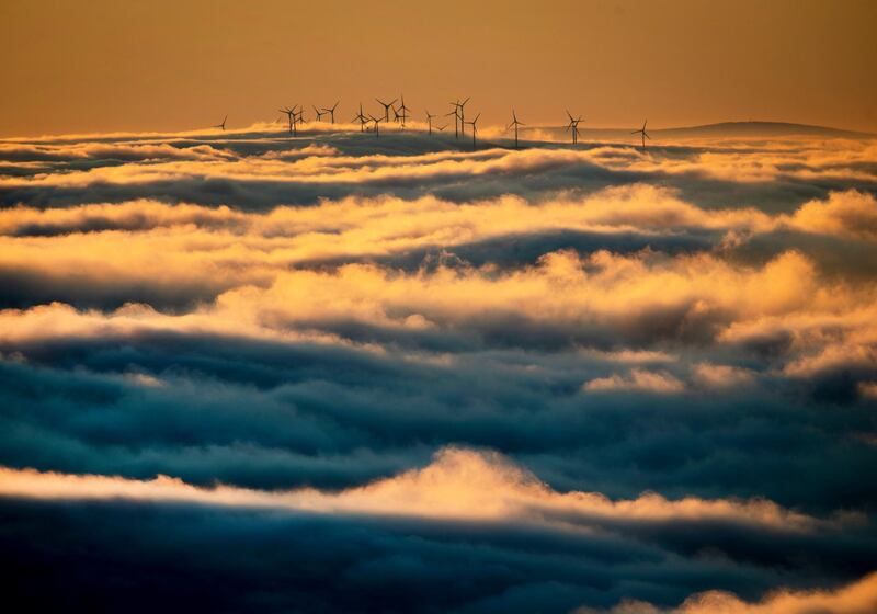 Wind turbines stand on a hill and are surrounded by fog and clouds in the Taunus region near Frankfurt, Germany, Monday, Jan. 6, 2020. (AP Photo/Michael Probst)