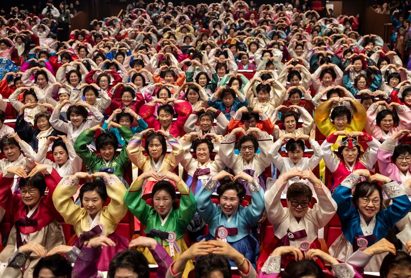 Graduates make heart gestures during their commencement ceremony in Seoul. EPA