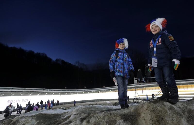 Children wait for the start of the final run during the men's doubles luge on Wednesday in Krasnaya Polyana. Natacha Pisarenko / AP