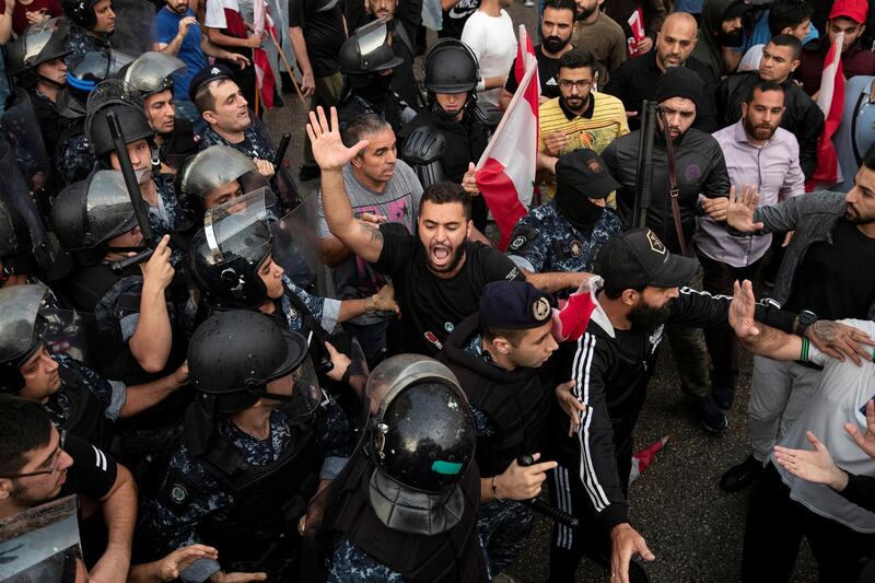 A demonstrator reacts as riot police interfere to stop demonstrators scuffling with each other in Beirut. Reuters