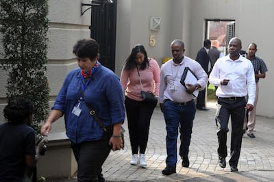 Members of the South African Asset Forfeiture Unit and other law enforcement agencies arrive to search the Gupta family compound on April 16, 2018 in Johannesburg. 
South African officials on April 16 raided a Johannesburg property belonging to the Guptas, the wealthy business family at the heart of graft allegations against former president Jacob Zuma. The Hawks police investigative unit and the tax service descended on the Guptas' heavily protected compound in the upmarket suburb of Saxonwold.
 / AFP PHOTO / STRINGER