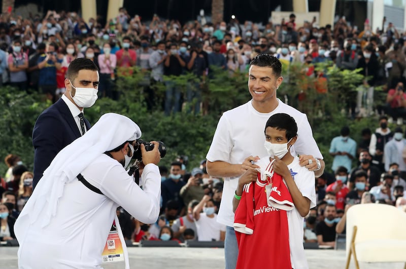 Cristiano Ronaldo gives an autographed shirt to a young fan.
