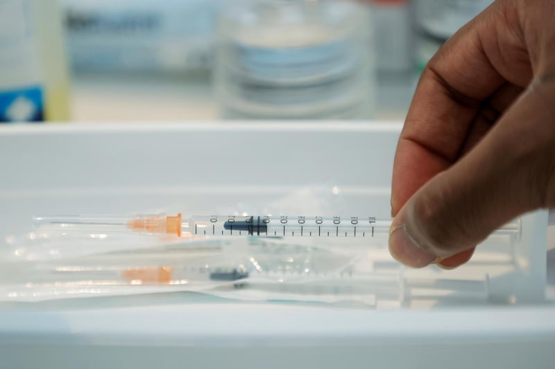 FILE PHOTO: A medical worker grabs a syringe containing a dose of the Pfizer-BioNTech COVID-19 vaccine at a coronavirus disease (COVID-19) vaccination center in Neuilly-sur-Seine, France, February 19, 2021. REUTERS/Sarah Meyssonnier/File Photo