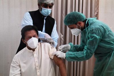 This image grab taken from a handout video released on March 18, 2021 by the Pakistan Prime Minister Office shows Pakistan's Prime Minister Imran Khan (L) receiving a dose of the Chinese-made Sinopharm vaccine  against the Covid-19 coronavirus, at the Prime Minister House in Islamabad. Khan has tested positive for Covid-19, his office said on March 20, just two days after he was vaccinated against the disease. - RESTRICTED TO EDITORIAL USE - MANDATORY CREDIT "AFP PHOTO/Pakistan Prime Minister Office" - NO MARKETING - NO ADVERTISING CAMPAIGNS - DISTRIBUTED AS A SERVICE TO CLIENTS
 / AFP / Pakistan Prime minister office / - / RESTRICTED TO EDITORIAL USE - MANDATORY CREDIT "AFP PHOTO/Pakistan Prime Minister Office" - NO MARKETING - NO ADVERTISING CAMPAIGNS - DISTRIBUTED AS A SERVICE TO CLIENTS
