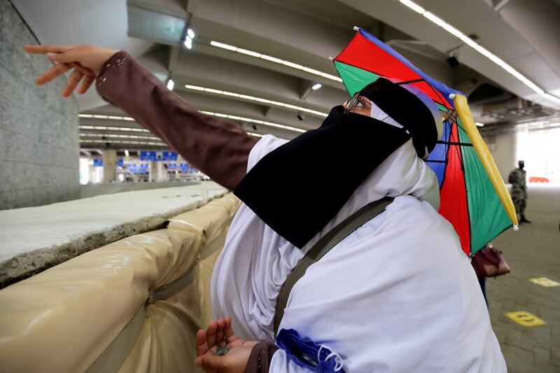 A Hajj pilgrim in Mina, near Makkah, casts a stone at a pillar representing Satan.