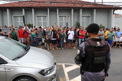 A crowd gathers outside the police station where the perpetrator of the two school shootings was being held. AFP