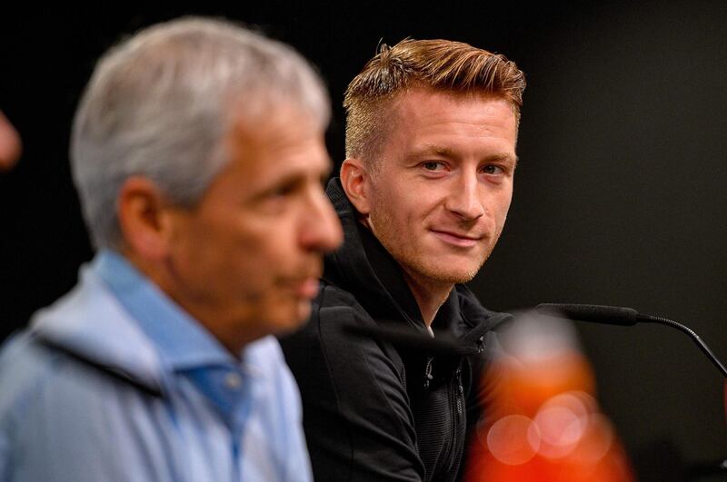 Dortmund's Swiss coach Lucien Favre and Dortmund's German forward Marco Reus are pictured during a press conference in Dortmund, western Germany, on September 16, 2019 on the eve of the UEFA Champions League Group F football match between Borussia Dortmund and Barcelona. / AFP / SASCHA SCHUERMANN
