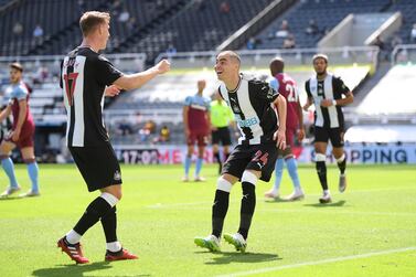 Miguel Almiron, right, celebrates with teammate Emil Krafth after scoring Newcastle's opening goal in the 2-2 draw with West Ham on Sunday, July 5. AP