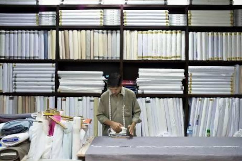 Faisal Mughal, of Bader Al Layali Gents Tailoring , works until 3am to meet the demand for new clothing for the upcoming Eid. Antonie Robertson / The National