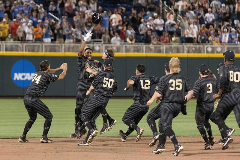 Vanderbilt's Jayson Gonzalez, second from left, tosses his helmet while celebrating with teammates after driving in the winning run against Arizona in the 12th inning of a baseball game in the NCAA College World Series on Saturday, June 19, 2021, in Omaha, Neb. (AP Photo/Rebecca S. Gratz)