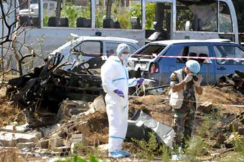 Forensic experts search for evidence in the bus wreckage at the site of explosion in the northern city of Tripoli, Lebanon, Monday, Sept. 29, 2008. A car bomb exploded Monday near a military bus carrying troops on their way to work in northern Lebanon, killing five people and injuring 26, Lebanese security officials said. (AP Photo/Ahmad Omar) *** Local Caption ***  BEI115_Mideast_Lebanon_Explosion.jpg