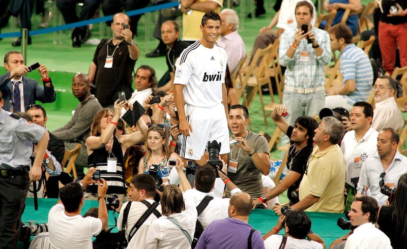 Real Madrid's new player Portuguese Cristiano Ronaldo (C) smiles during his official presentation at the Santiago Bernabeu stadium in Madrid on July 6, 2009. Real acquired the 24-year-old Portuguese striker from Manchester United last month on a six-year deal worth 94 million euros (131 million dollars) and Spanish media reports that he will be paid 13 million euros each season. AFP PHOTO / SALVADOR RODRIGUEZ (Photo by SALVADOR RODRIGUEZ / AFP)