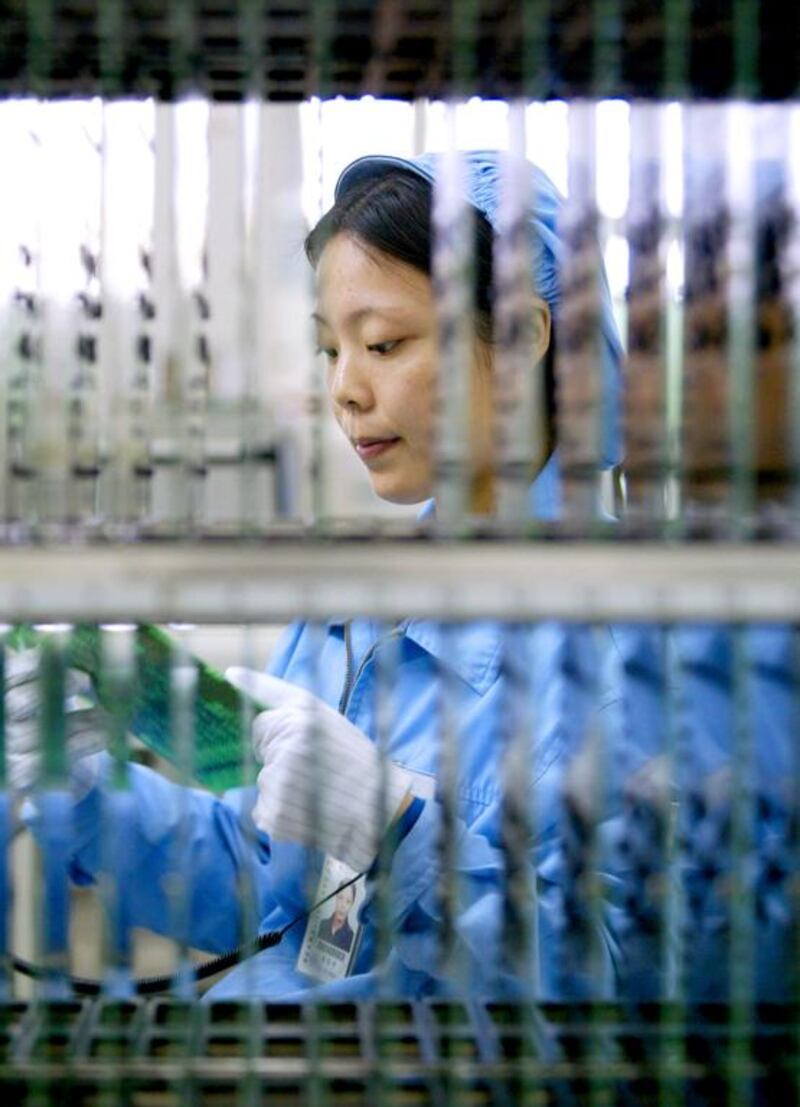 A Huawei worker checks an electronic board for a computer in Dongguan. Kin Cheung / Reuters