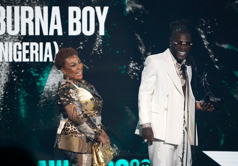 Burna Boy, of Nigeria, accepts the Best International Act award as his mother Bose Ogulu looks on. AP
