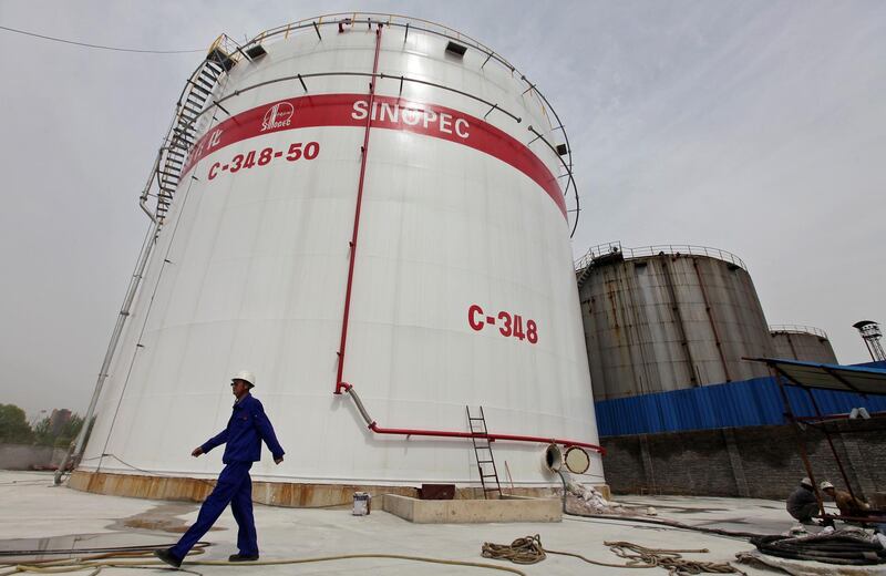 FILE PHOTO: An employee walks past oil tanks at a Sinopec refinery in Wuhan, Hubei province, China April 25, 2012. To match Exclusive USA-TRADE/CHINA-OIL REUTERS/Stringer/File Photo CHINA OUT.