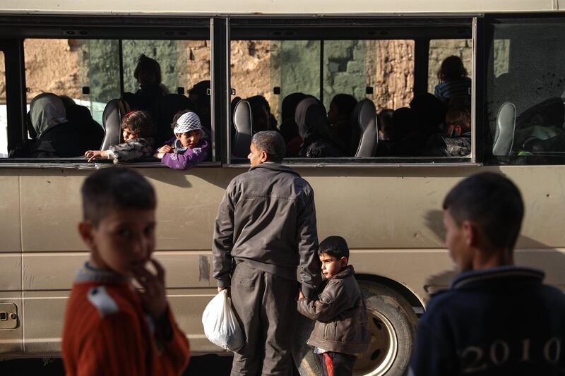 A man talks with his relatives seated inside a bus during the evacuation in rebel-held Douma, Syria, on March 17, 2018. Mohammed Badra / EPA