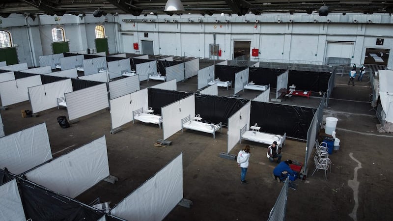 Workers install a temporary Doctors Without Borders (MSF) 50 places shelter for homeless people suspected of being infected with the novel coronavirus (COVID-19) in Brussels.   AFP