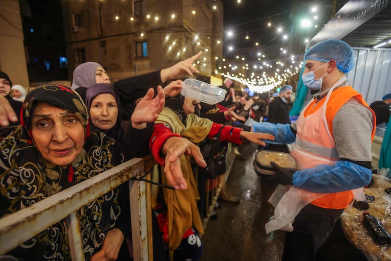 A volunteer distributes food for suhoor in Beirut. AFP