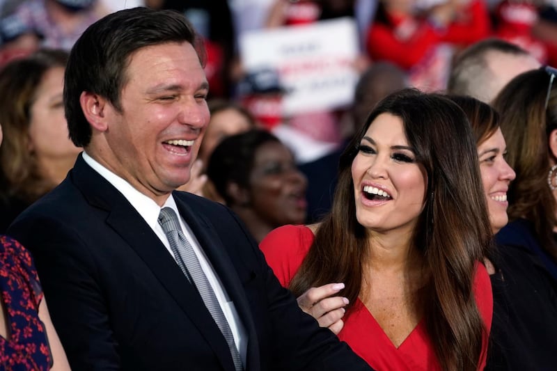 Florida Gov. Ron DeSantis and Kimberly Guilfoyle smile as President Donald Trump speaks during a campaign rally at Orlando Sanford International Airport, in Sanford, Fla. AP Photo