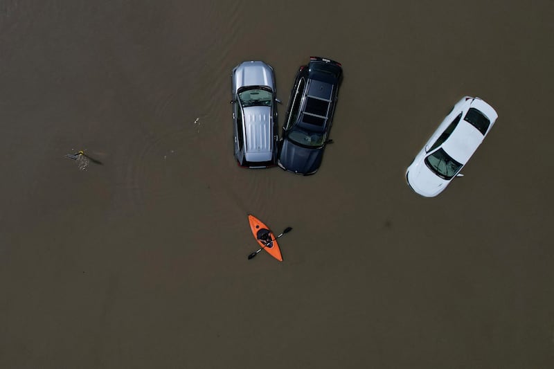 A canoeist paddles past cars in the worst floods to hit Vermont since Hurricane Irene in 2011. Reuters
