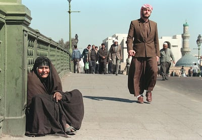 An elderly Iraqi woman beggs in Baghdad, 22 February. Iraq lives under seven-year-old UN sanctions in force since it invaded Kuwait in 1990. (Photo by PATRICK BAZ / AFP)