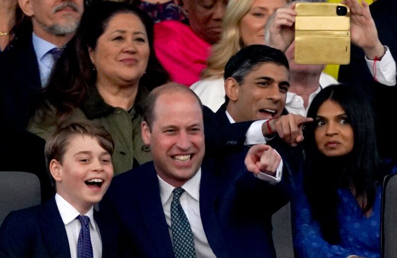 Prince George and his father Prince William enjoy the show, alongside Mr Sunak and Ms Murty. AFP