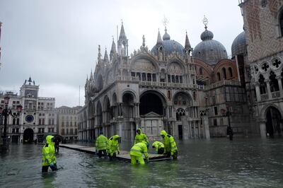 FILE PHOTO: Workers put up a platform at a flooded St. Mark's Square during a period of seasonal high water in Venice, Italy, November 24, 2019. REUTERS/Manuel Silvestri/File Photo