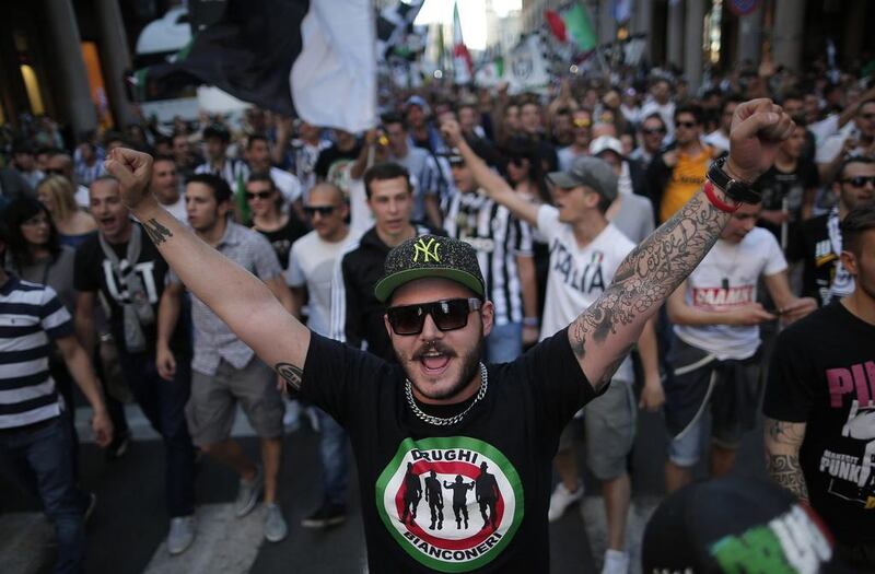A Juventus supporter holds his hands in the air at the Piazza San Carlo in Turin on Sunday after the club won the Serie A title. Marco Bertorello / AFP / May 4, 2014