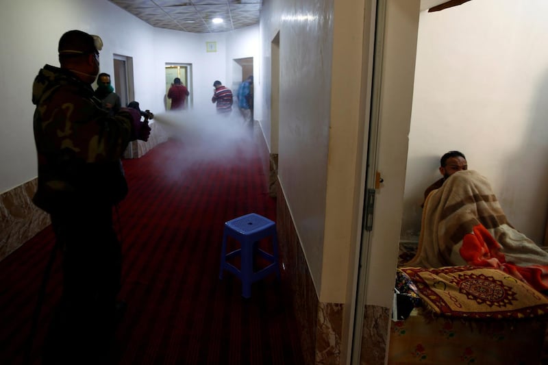 A member of a medical team sprays disinfectant to sanitise houses during a curfew, which was imposed to prevent the spread of the coronavirus in the holy city of Najaf, Iraq. Reuters