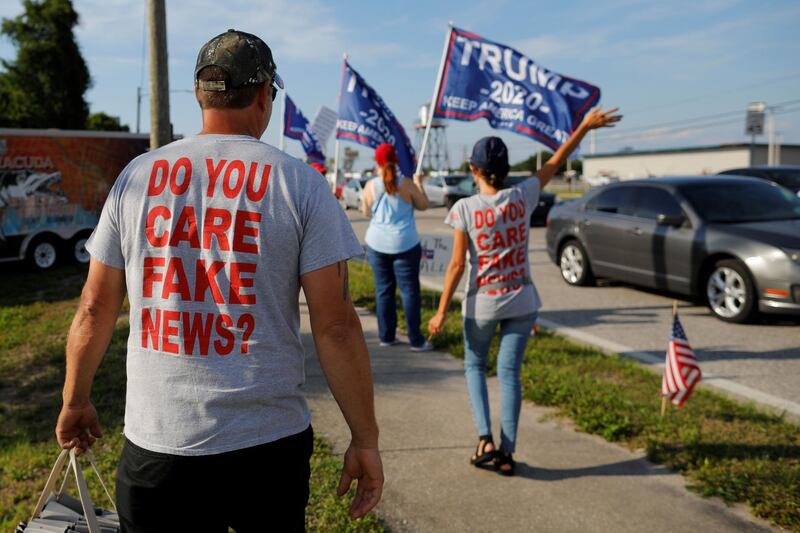 Supporters of U.S. President Donald Trump, wearing t-shirts reading "Do You Care Fake News?" wave to passing drivers during a roadside sign waving rally in the Pinellas County city of Clearwater, Florida, U.S., May 15, 2019.  Picture taken May 15, 2019.    REUTERS/Brian Snyder