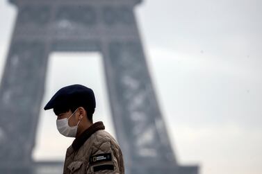 A tourist wears a face mask near the Eiffel Tower in Paris, France. The Global Manufacturing and Industrialisation Summit (GMIS) that was to be held at the Hannover in April will be held virtually due to spread of the coronavirus. EPA