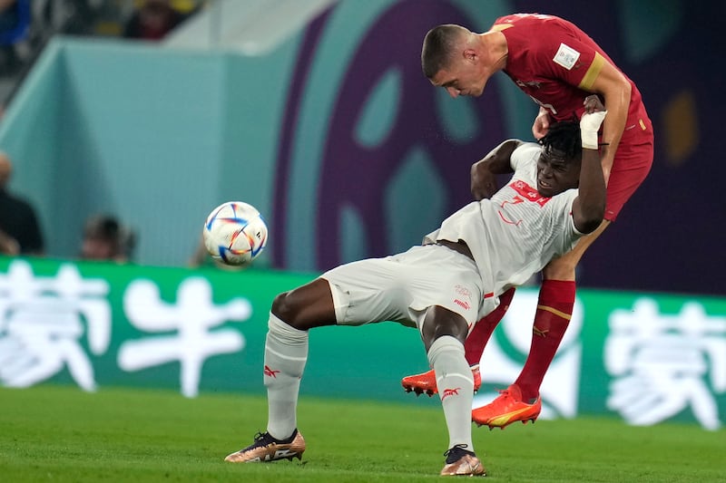 Serbia's Nikola Milenkovic, right, and Switzerland's Breel Embolo, challenge for the ball during the World Cup group G soccer match between Serbia and Switzerland, in Doha, Qatar. AP Photo
