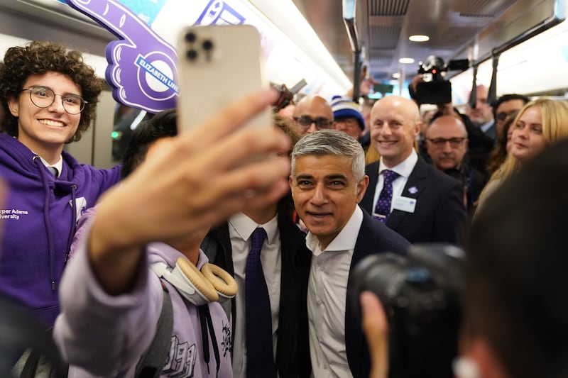 Mr Khan poses for a picture on the first Elizabeth line train to carry passengers, at Paddington station. PA