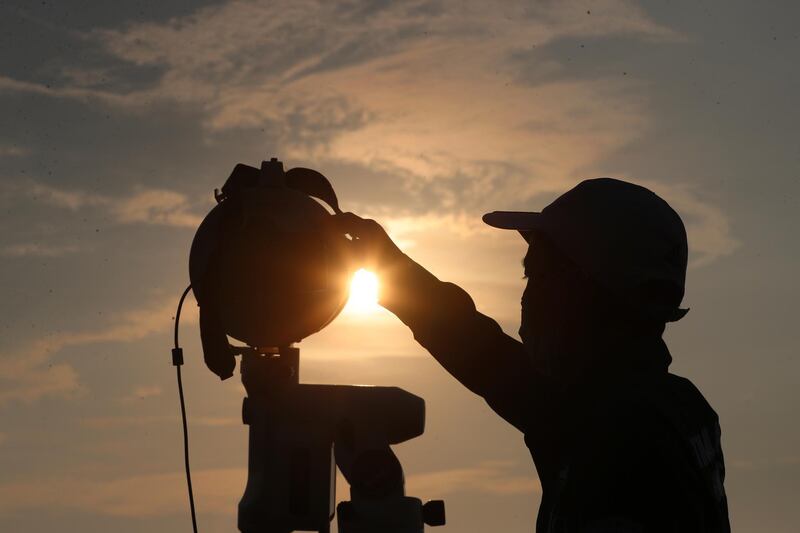 An official is silhouetted as he uses a telescope to scan the horizon for a crescent moon that will determine the beginning of the holy fasting month of Ramadan in Jakarta, Indonesia, Monday, April 12, 2021.(AP Photo/Achmad Ibrahim)
