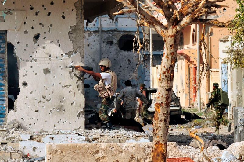 An anti-Gaddafi fighter returns fire during clashes with Gaddafi forces in Sirte October 19, 2011. REUTERS/Esam Al-Fetori (LIBYA - Tags: POLITICS CONFLICT) *** Local Caption ***  EF05_LIBYA_1019_11.JPG