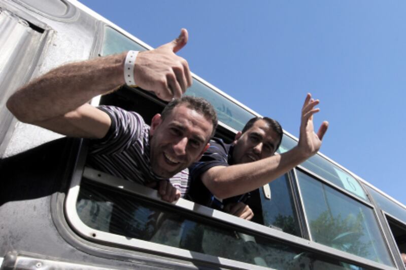 epa02970604 Palestinian prisoners react as they arrive at the Rafah Egypt-Gaza border crossing, in Rafah, Egypt, 18 October 2011. According to media reports, Palestinian prisoners freed on 18 October in a prisoner exchange with Israel crossed over into the Gaza Strip from Egypt, witnesses said. They were met by Hamas leaders and by their families, who were to accompany them to Gaza City, where official celebrations for their release were to take place.  The buses with the prisoners had earlier left Israel for Egypt, as Gilad Shalit, an Israeli soldier held captive for five years by Hamas, left the Gaza Strip for Israel, as part of the exchange deal.  EPA/KHALED ELFIQI *** Local Caption ***  02970604.jpg