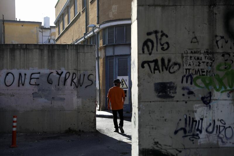 A man walks next to a concrete wall of an old military post near the UN-controlled buffer zone in Nicosia, Cyprus, April 27, 2021. REUTERS/Yiannis Kourtoglou