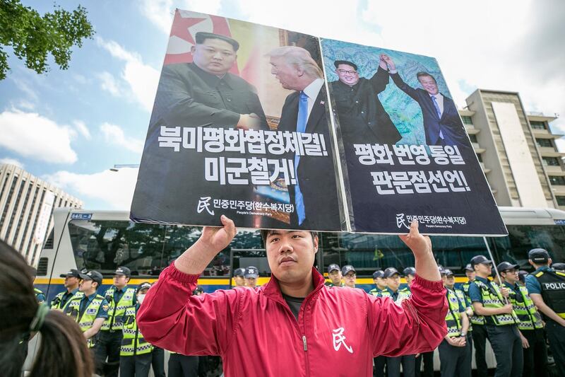 A demonstrator holds placards during an anti-US rally in front of the US Embassy in Seoul, South Korea. Jean Chung / Bloomberg