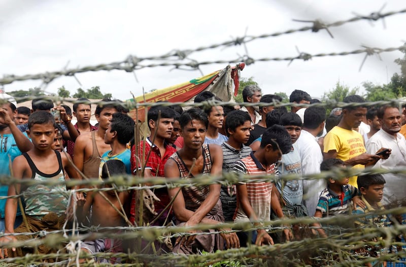 epa07031825 (FILE) - Rohingya refugees gather near a fence at the 'no man's land' zone at the Bangladesh-Myanmar border in Maungdaw district, Rakhine State, western Myanmar, 24 August 2018 (reissued 19 September 2018). Chief Prosecutor of the International Criminal Court (ICC), Fatou Bensouda released a statement on 18 September 2018, announcing the opening of a preliminary examination into Myanmar's alleged deportation of Rohingya people from Myanmar to Bangladesh, as well as other potential crimes. The preliminary examination will determine whether there is enough evidence to proceed with a full investigation. Since Myanmar is not an ICC state party, but Bangladesh is, the court 'may exercise jurisdiction over conduct to the extent it partly occurred on the territory of Bangladesh,' she said. A UN independent mission on Myanmar released a report on 18 September 2018, examining the situation in three Myanmar states over 15 months, making recommendations to the UN, the international community and to the Myanmar Government to investigate and prosecute the country's military leaders for 'genocide, crimes against humanity and war crimes.' Thousands of Rohingya people fled the violence in Myanmar since August 2017, to find refuge in neighboring Bangladesh.  EPA/NYEIN CHAN NAING *** Local Caption *** 54573514