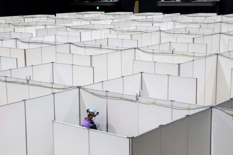 An employee works to set up a medical facility to accomodate coronavirus patients with mild symptoms at the Nippon Foundation Para Arena in Tokyo. Japan's government prepared on May 4 to extend its nationwide state of emergency to the end of May as it braces for a lengthy battle against the pandemic.  AFP
