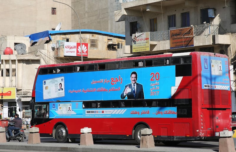 A bus displays a poster advising people to check about their voting information ahead of Iraq's parliamentary elections, on January 16, 2018, in the capital Baghdad. / AFP PHOTO / SABAH ARAR