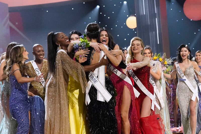 Gabriel, back to camera, is hugged by other contestants after being crowned Miss Universe. AP