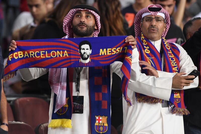 A Barcelona fan holds a scarf depicting Messi. AFP