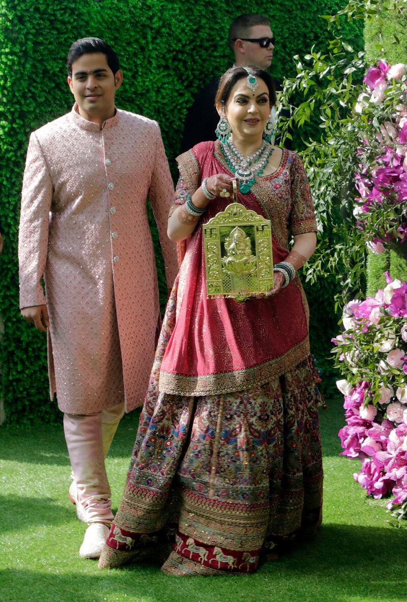 Nita Ambani, wife of Reliance Industries Chairman Mukesh Ambani, arrives with her son Akash Ambani for his wedding. Photo: AP