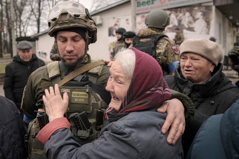 A woman hugs a Ukrainian soldier after a convoy of military and aid vehicles arrived in the formerly Russian-occupied Kyiv suburb of Bucha. AP