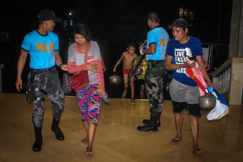 Police assist residents arriving at an evacuation centre, as typhoon Phanfone makes landfall, in Borongan, Eastern Samar province, central Philippines. AFP